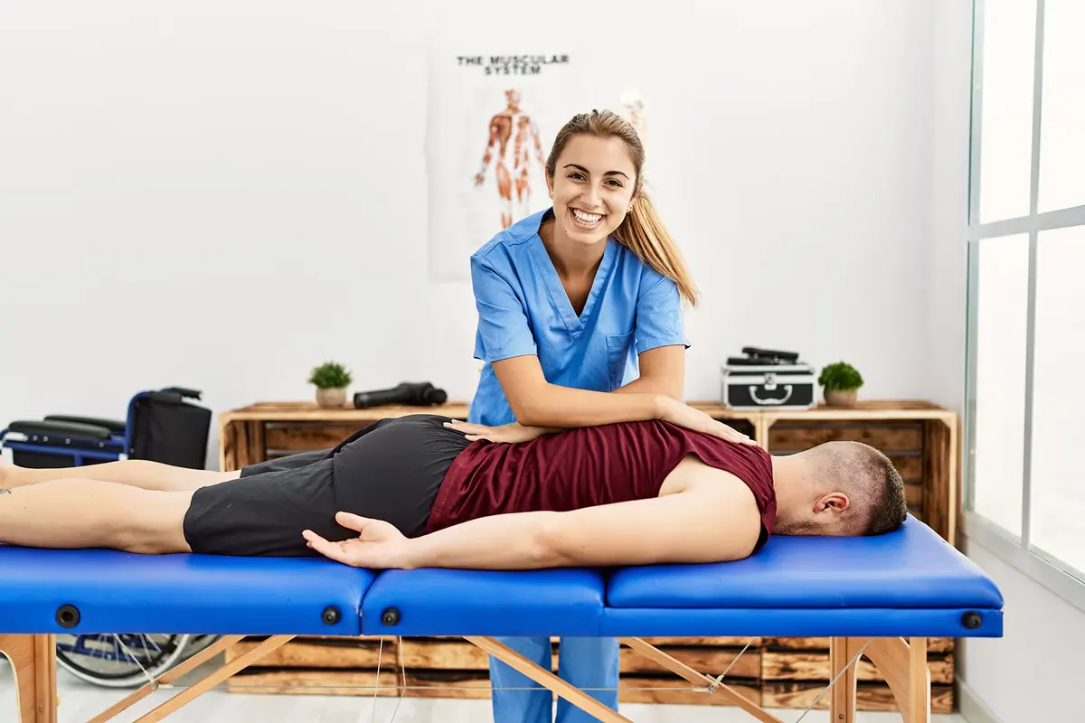 Physiotherapeutin behandelt einen Patienten auf der Liege